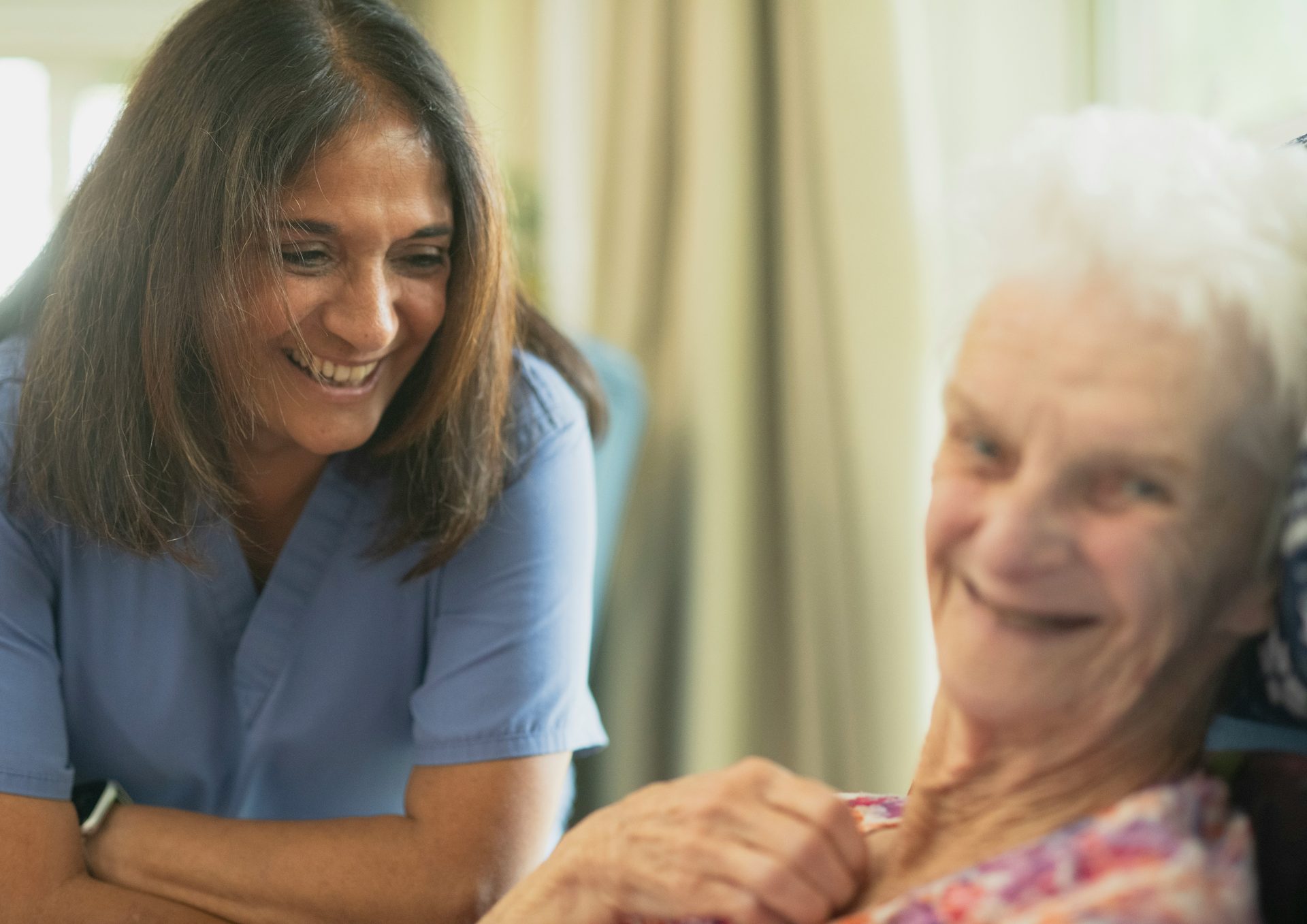 Caregiver assisting an elderly person with daily living support at home.