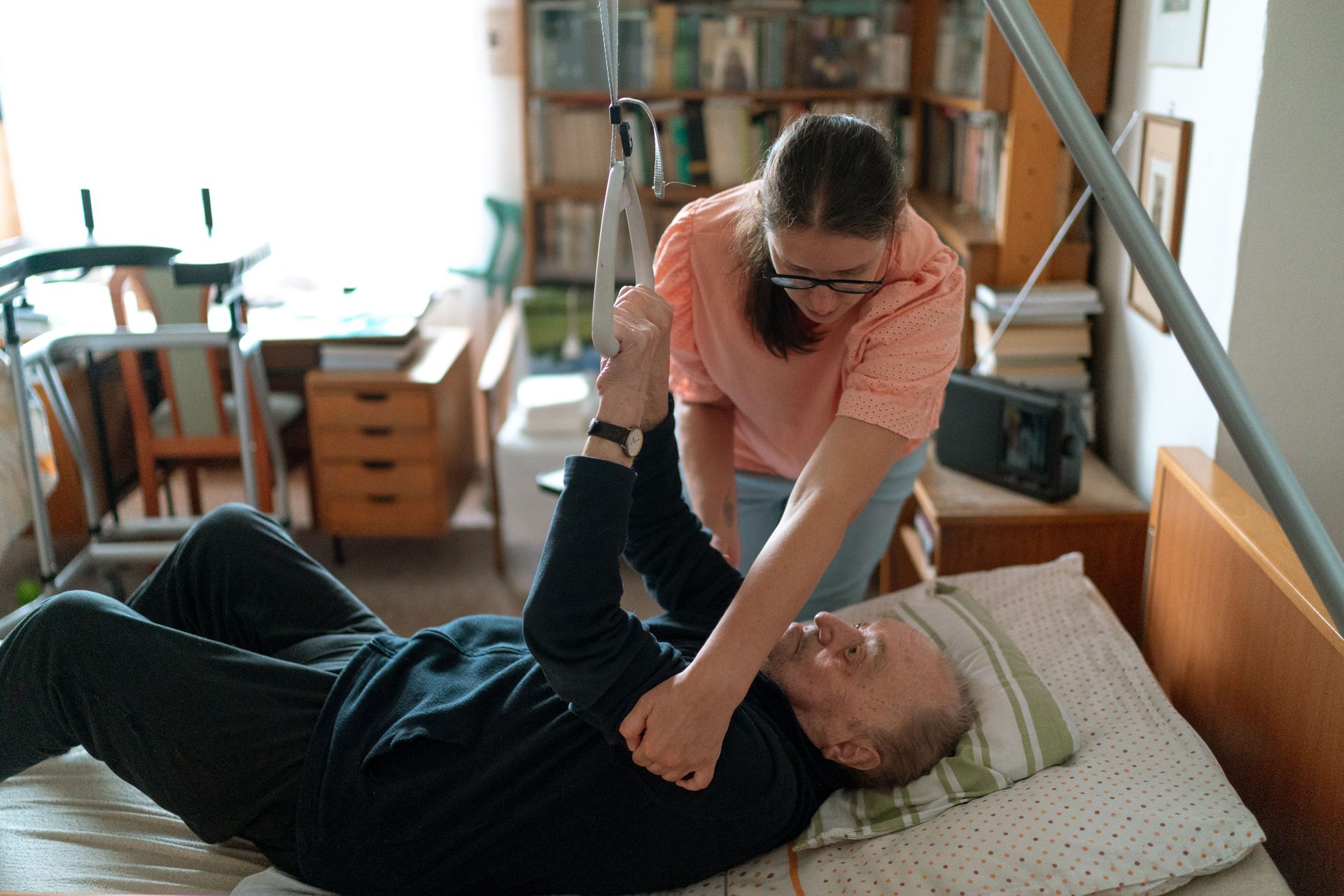 A caregiver providing hands-on mobility support during a resident's daily routine, reflecting the rehabilitation-informed approach at Northern Edge Transitional Care.